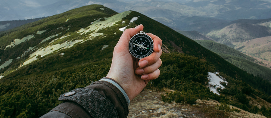 man's hand holding compass